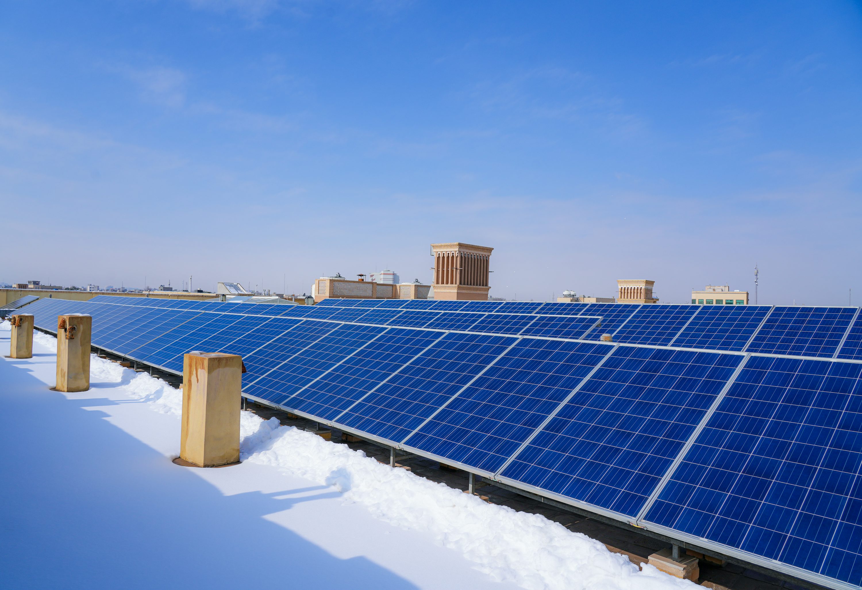 Commercial rooftop solar panels under blue sky